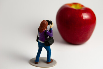 photographer action figure photographing a large apple