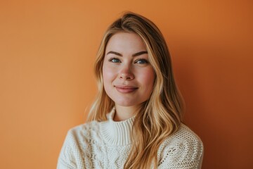 Portrait of a beautiful young woman with blond hair on a orange background