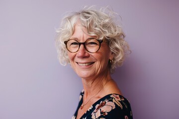 Portrait of smiling senior woman with eyeglasses against violet background