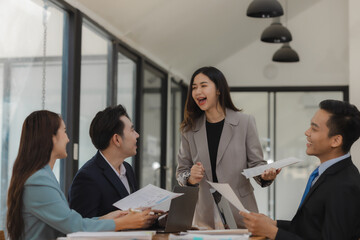 A group of employees happily work together in the office while discussing work that was completed on time as ordered by their boss, A group of entrepreneurs had fun working together.