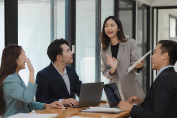 A group of employees happily work together in the office while discussing work that was completed on time as ordered by their boss, A group of entrepreneurs had fun working together.