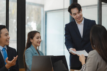 A group of employees happily work together in the office while discussing work that was completed on time as ordered by their boss, A group of entrepreneurs had fun working together.