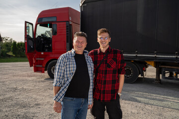 Father and son starting trucking company, satisfied trucker and fleet manager standing together 