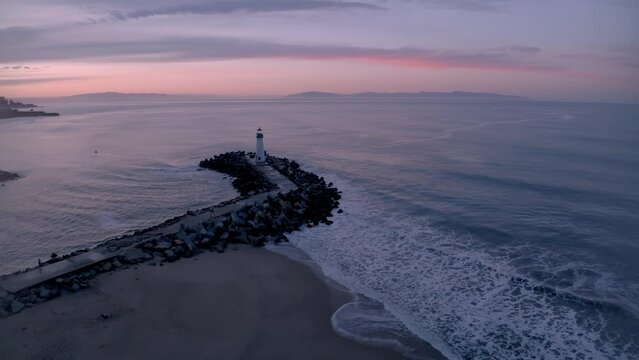 Santa Cruz California harbor lighthouse with drone approaching from harbor at sunrise