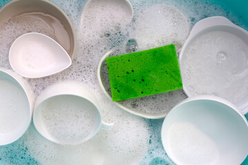 Plates and bowl soaking in foam of dishwashing liquid