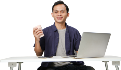 joyfull happy asian man at workplace while sitting in front of laptop computer. on isolated background