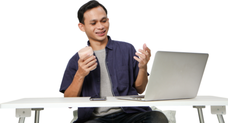 joyfull happy asian man at workplace while sitting in front of laptop computer. on isolated background