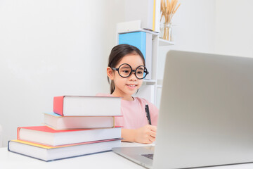 Cute little Girl asia Study At Home With Laptop And Wireless Headphones