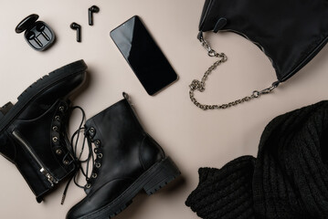 Total black accessories on beige background. Flat lay, top view.