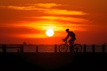 Fototapeta premium Breathtaking sunset scenery enhanced by a solitary bicycle silhouette