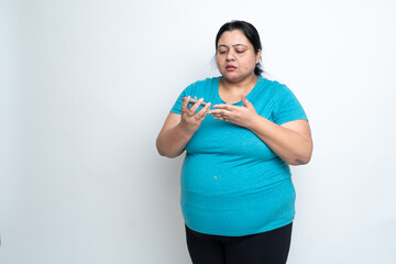 Overweight fat indian woman doing blood sugar test. isolated over white background. Plus size female. healthcare concept. Copy Space