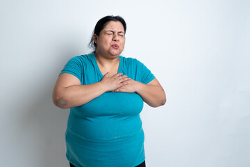 Overweight fat indian woman putting hand on her chest and having heart problems or suffering from...