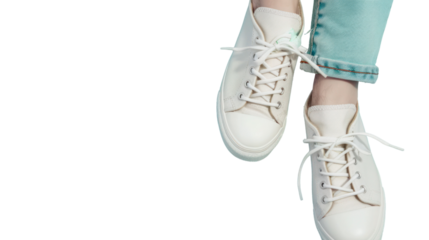 The hand holds by shoelaces Pair of fashion stylish white sneakers on pastel blue background. 