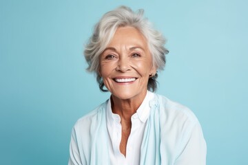 Cheerful senior woman looking at camera and smiling on blue background