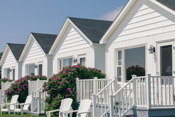 petites maisons blanches avec petit balcon bien aménagé devant la porte d'entrée et une grande...