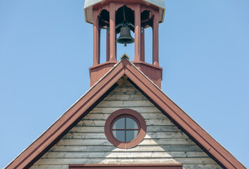vue sur le toit d'une église avec un toit en bois en angle et un clocher sur fond de ciel bleu...