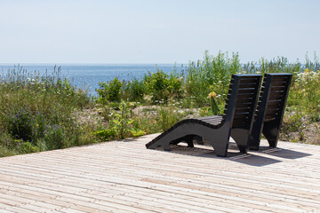 banc de type chaise longue dans un lieu publique avec un sol en bois en bord de mer lors d'une...