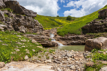 Fototapeta na wymiar the source of the mountain river originates in the mountains on alpine meadows.