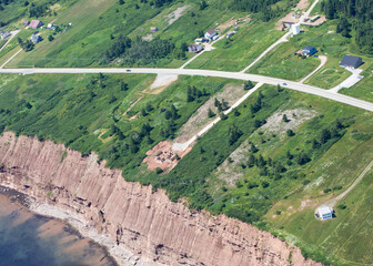 vue d'un terrain en hauteur avec une falaise au bord de la mer en été avec du gazon vert