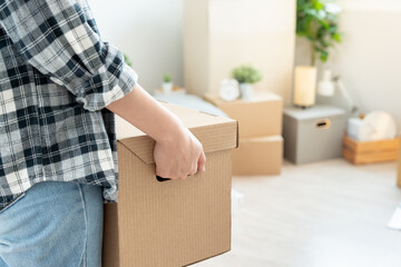 Moving house, relocation. Woman hold carton box contain equipment for new condominium, inside the...