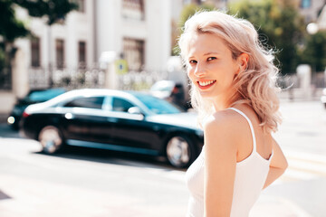 Closeup portrait of young beautiful smiling woman. Sexy carefree model posing on the street background at sunset. Positive blond female. Cheerful and happy. Outdoors at sunny day