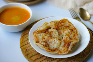 Roti Parata or Roti canai with curry sauce, a popular Malaysian breakfast