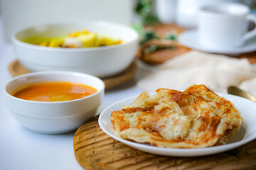 Roti Parata or Roti canai with curry sauce, a popular Malaysian breakfast