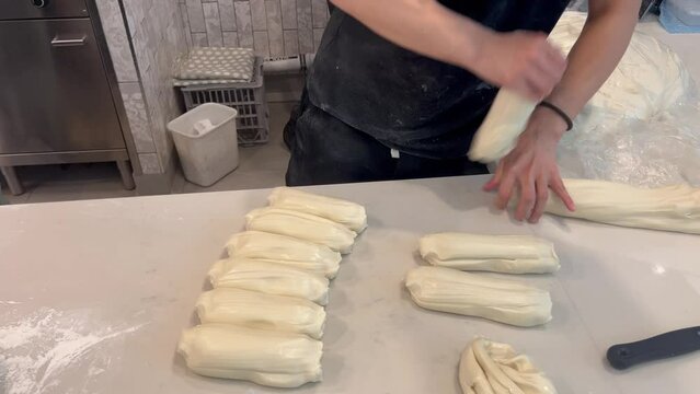 Unrecognizable Asian chef preparing dough for handmade pulled noodles