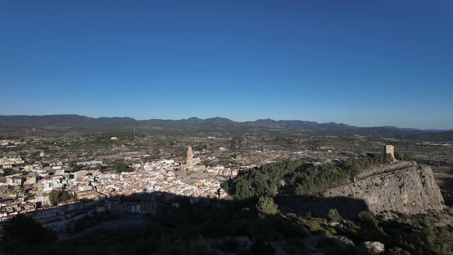 Evening shadow spreading across the valley and Spanish village of Jerica, Castellon. Mountainous landscape. Motionlapse panning sleft to right. Sunny day, unclouded. 4K
