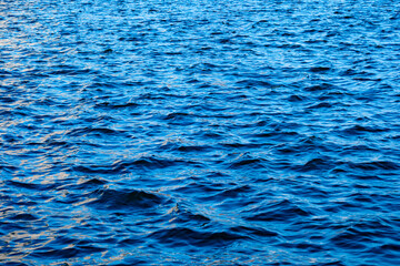 Deep sea waves. The surface of the blue sea has ripples and light reflecting on the sea.	