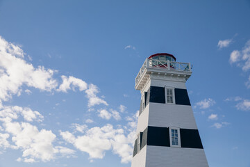 vue du top de la tour d'un phare peint en blanc et noir en été lors d'une journée ensoleillée