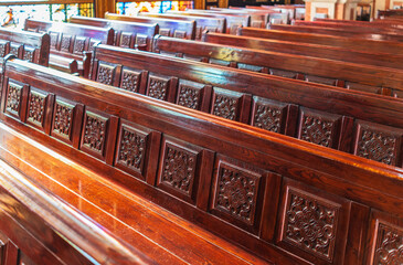 Empty wooden church benches of a Christian church. Blurry alter in the background. Selective focus....