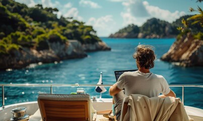 A man working on a laptop sitting on a luxury yacht