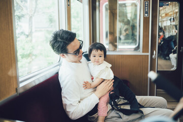 電車に座る赤ちゃんとお父さん