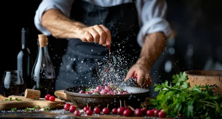 Fotobehang   A chef seasoning radishes in a skillet with wine bottles nearby © Shanti