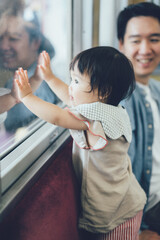 電車の窓の外を見る赤ちゃん