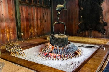 Traditional Japanese fireplace in a mountain hut cooking freshly caught Iwana (Grilled Char)