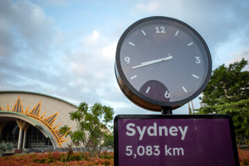 A purple traffic sign board of Sydney and a purple public clock, 5083 km from Sydney