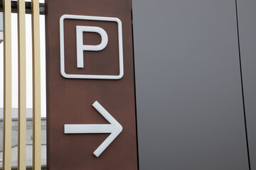 parking p arrow sign brown arrow car parked in city street urban area - obrazy, fototapety, plakaty