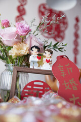 A Lego-like couple amidst traditional Chinese wedding decor, surrounded by blessings