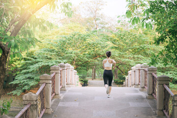 asian woman jogger, running over the bridge in public park. - obrazy, fototapety, plakaty