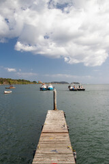 Wooden pier with boats and cloudy sky