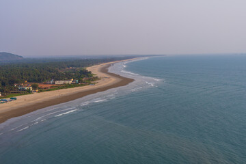 aerial view of Murudeshwar Beach in Karnataka, highlighting its vast, curving shoreline stretching into the horizon.