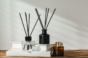 Aromatic Reed Diffuser on White Books With Shadows Playing on the Wall