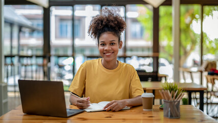 Smiling African American businesswoman, Young freelance business woman in casual look sitting work...