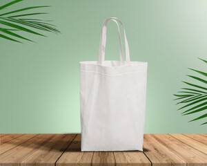 White Color Eco Friendly Tote Bag With Loop Strap. Non Woven Fabric Bag isolated on wood table with plants green background With copyspace for text