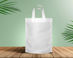 White Color Eco Friendly Tote Bag With Loop Strap. Non Woven Fabric Bag isolated on wood table with plants green background With copyspace for text