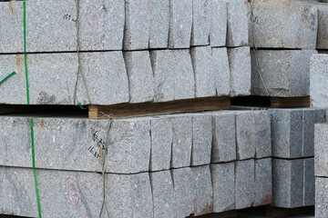 Baumaterial,  Randsteine aus Granit auf einem Lagerplatz