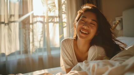 A Happy half Asian woman getting out of bed in the morning laughing. Happiness, waking up, relaxing, welcoming the new day. - obrazy, fototapety, plakaty