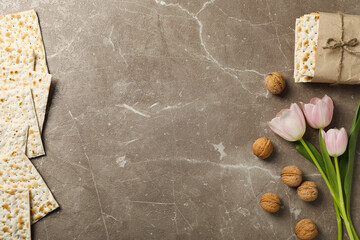 Matzo, nuts and flowers on gray background, space for text